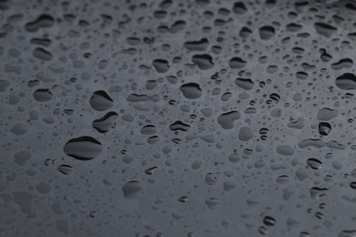 Water drops on grey glass surface, closeup