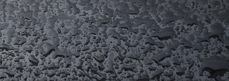 Photo of Water drops on grey glass surface, closeup