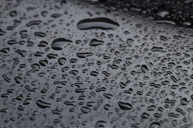 Photo of Water drops on grey glass surface, closeup