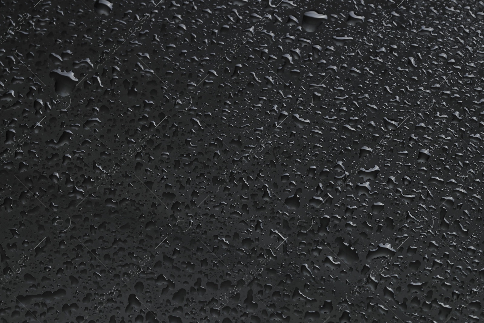 Photo of Water drops on grey glass surface, top view