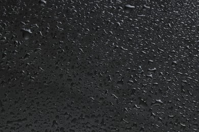 Water drops on grey glass surface, top view