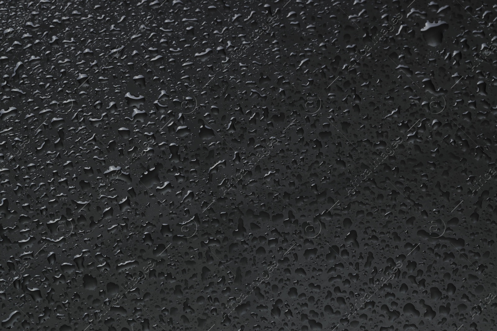 Photo of Water drops on grey glass surface, top view