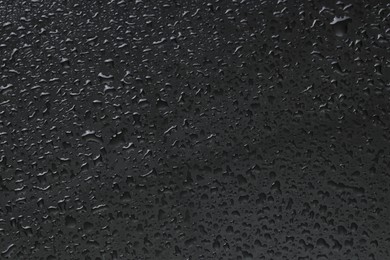 Water drops on grey glass surface, top view