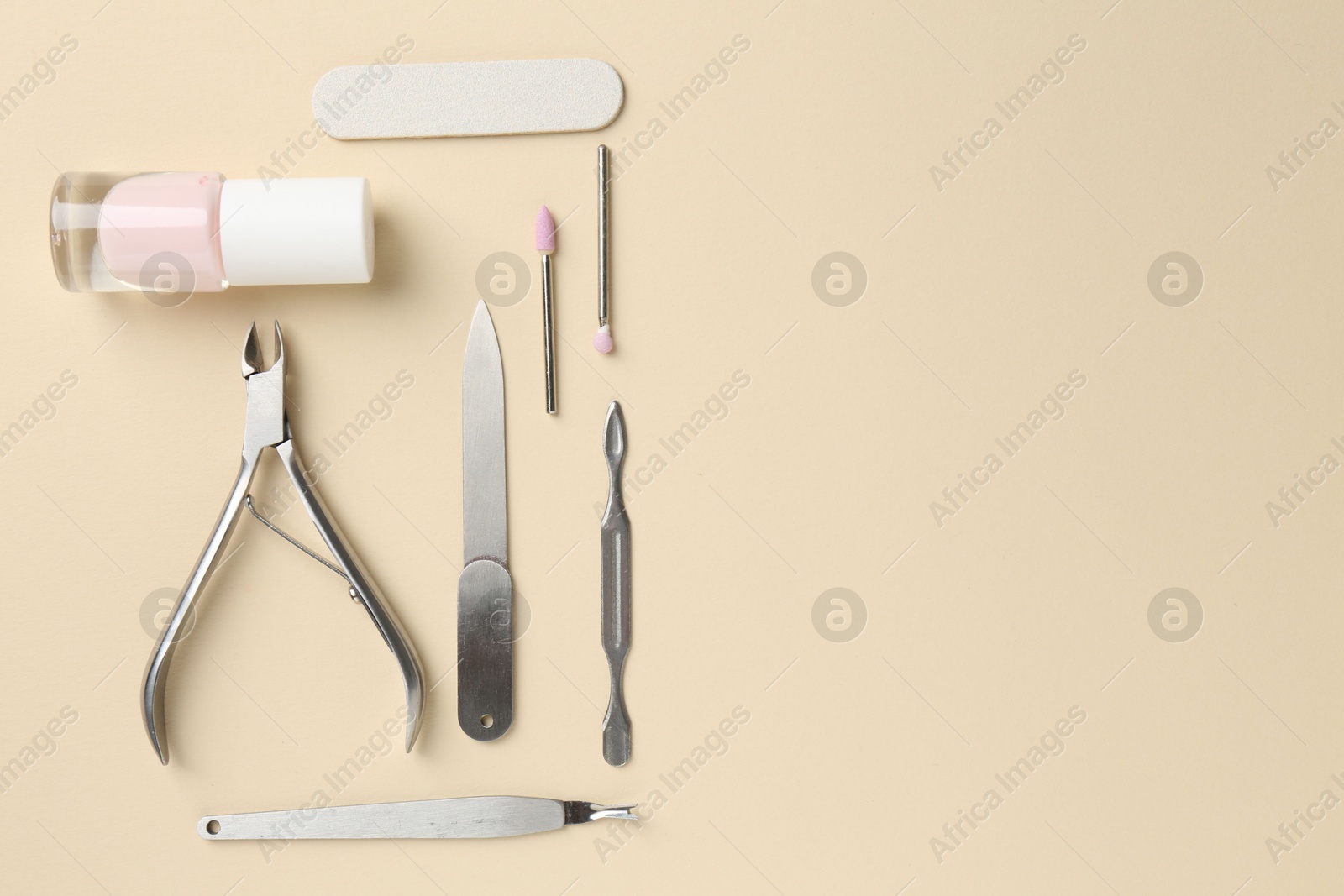 Photo of Set of pedicure tools on beige background, flat lay. Space for text