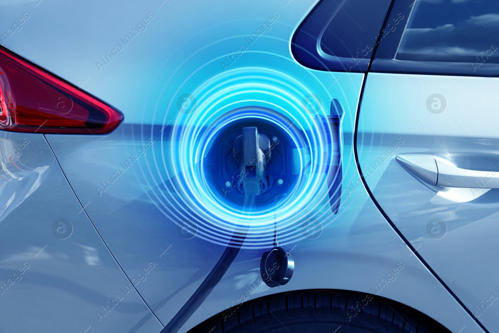 Image of Charging modern electric car from station outdoors. Round pulse waves representing energy