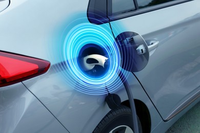 Image of Charging modern electric car from station outdoors. Round pulse waves representing energy