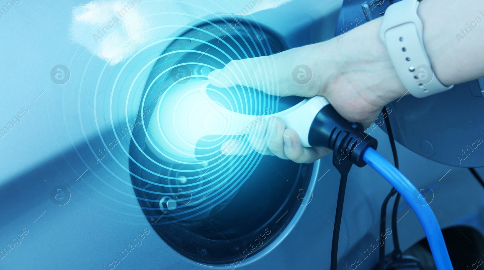 Image of Woman inserting plug into electric car socket at charging station outdoors, closeup. Banner design. Round pulse waves representing energy