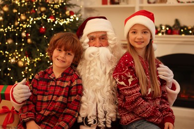 Photo of Christmas celebration. Santa Claus and kids at home