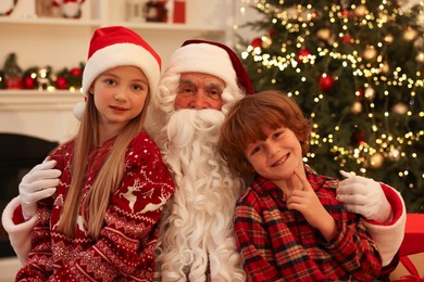 Photo of Christmas celebration. Santa Claus and kids at home