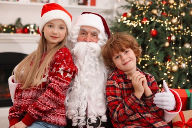 Photo of Christmas celebration. Santa Claus and kids at home