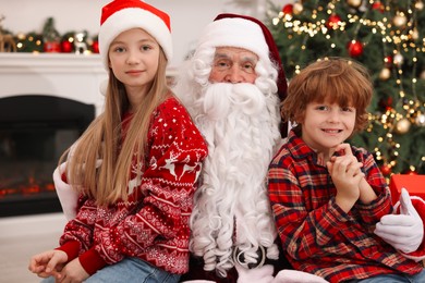 Photo of Christmas celebration. Santa Claus and kids at home