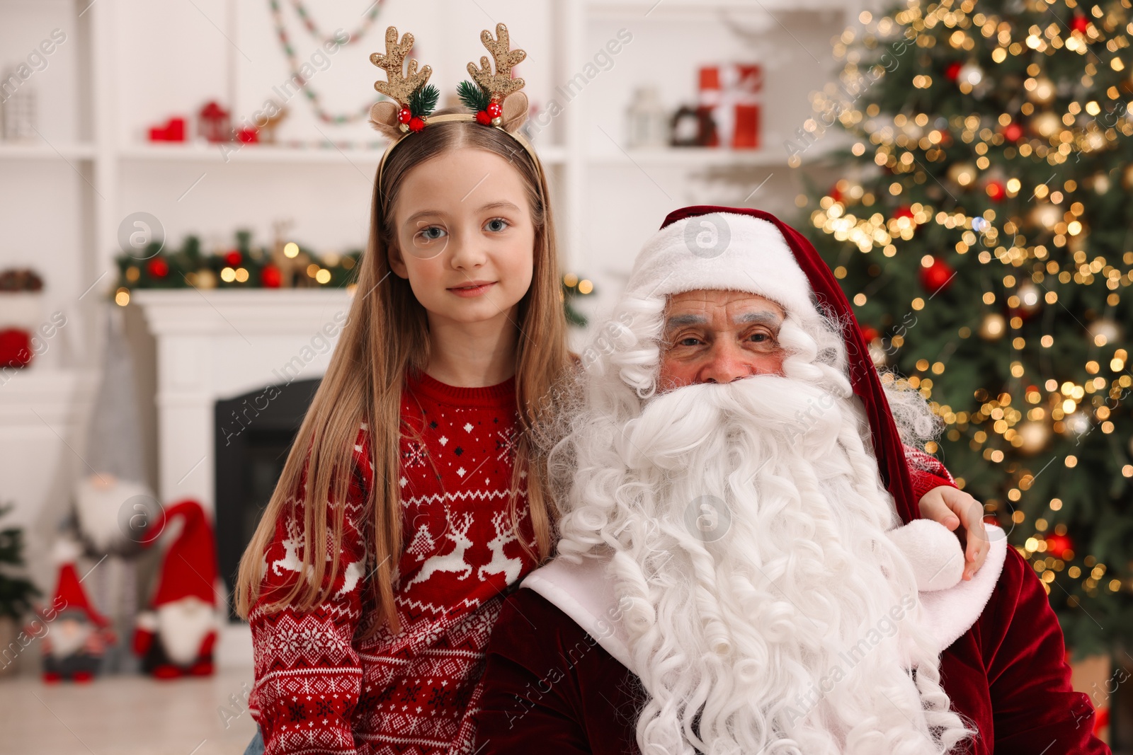 Photo of Christmas celebration. Santa Claus and girl at home