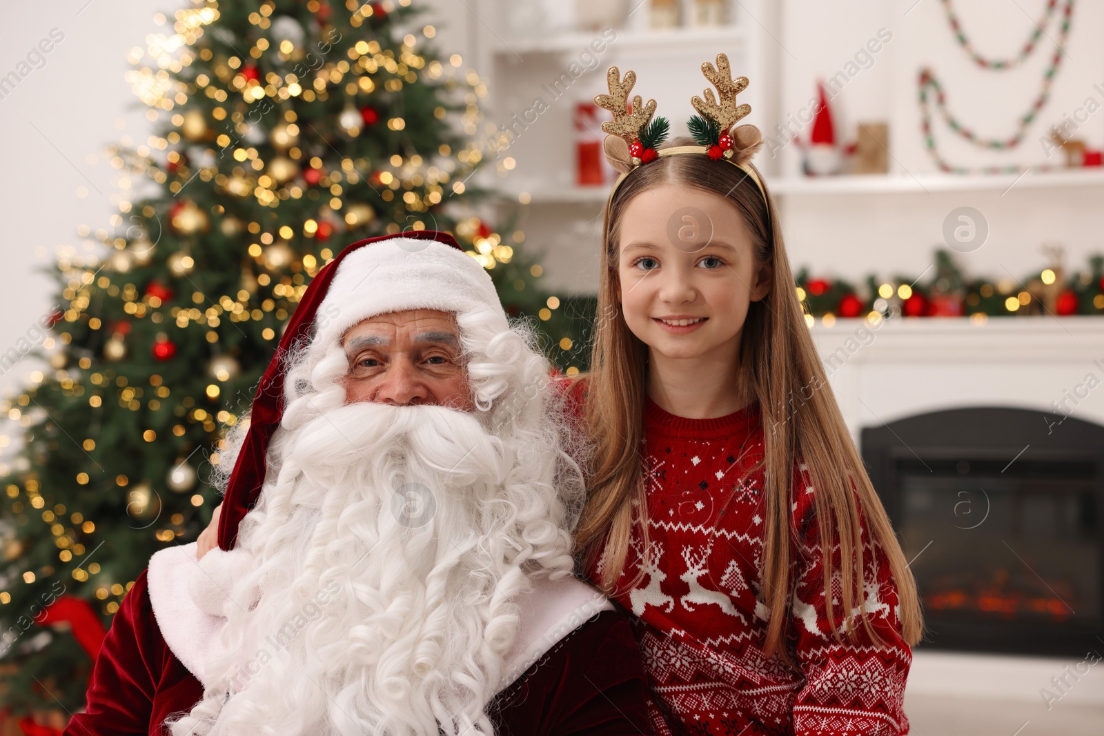 Photo of Christmas celebration. Santa Claus and girl at home