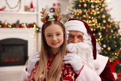 Photo of Christmas celebration. Santa Claus and girl at home