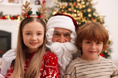 Photo of Christmas celebration. Santa Claus and children at home