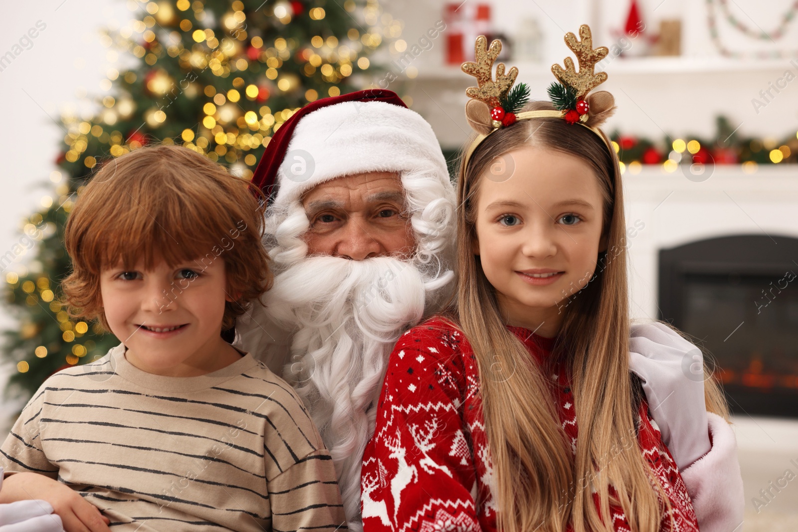 Photo of Christmas celebration. Santa Claus and children at home