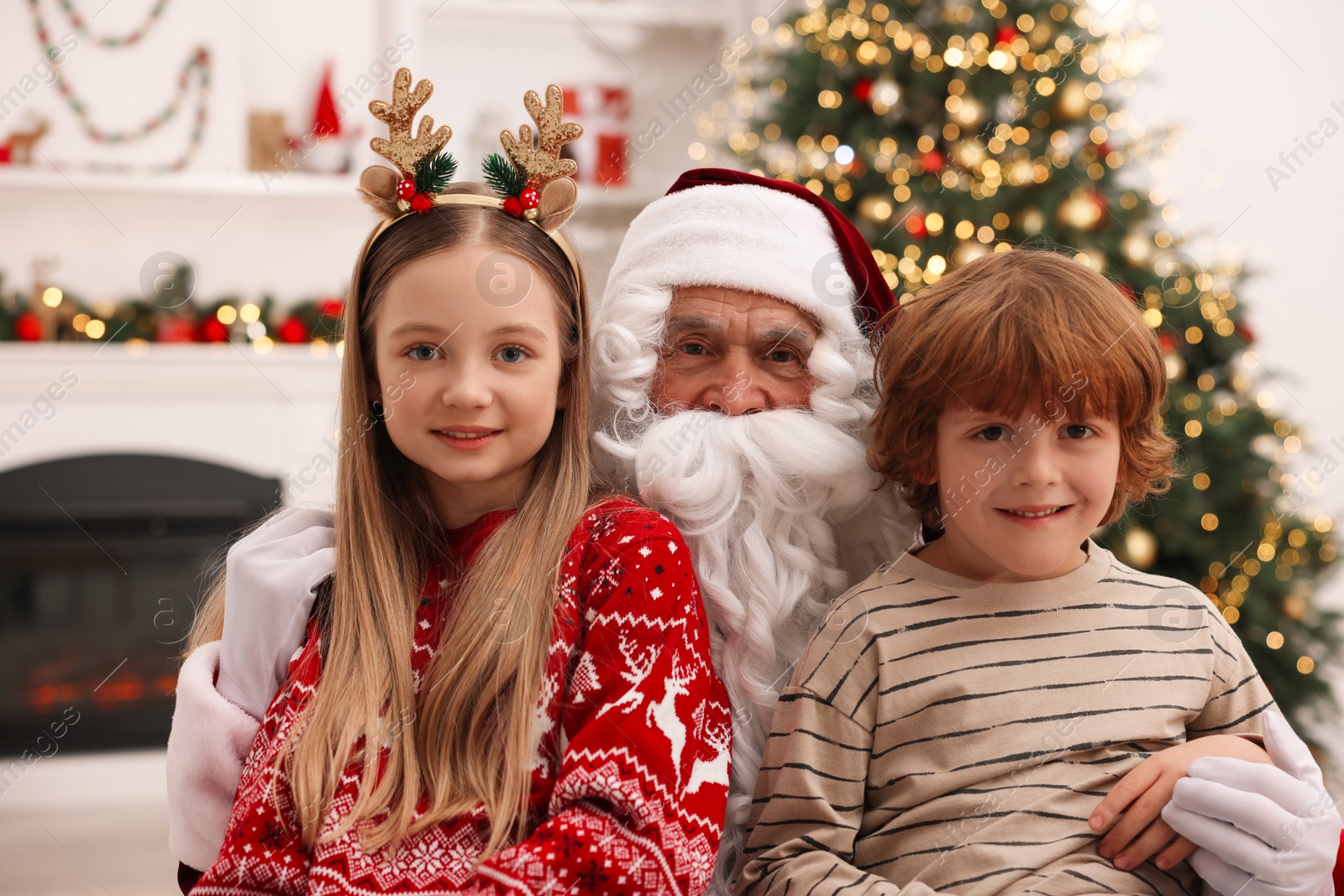 Photo of Christmas celebration. Santa Claus and children at home