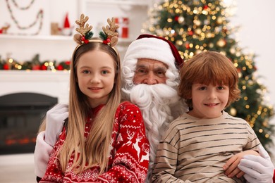 Photo of Christmas celebration. Santa Claus and children at home