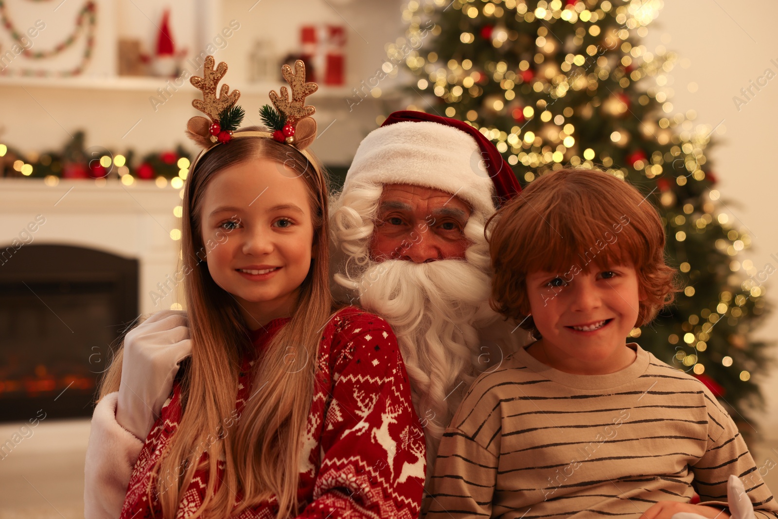 Photo of Christmas celebration. Santa Claus and children at home