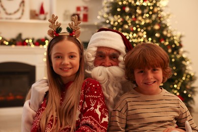 Photo of Christmas celebration. Santa Claus and children at home