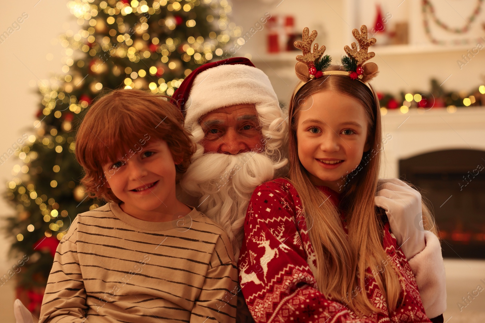 Photo of Christmas celebration. Santa Claus and children at home