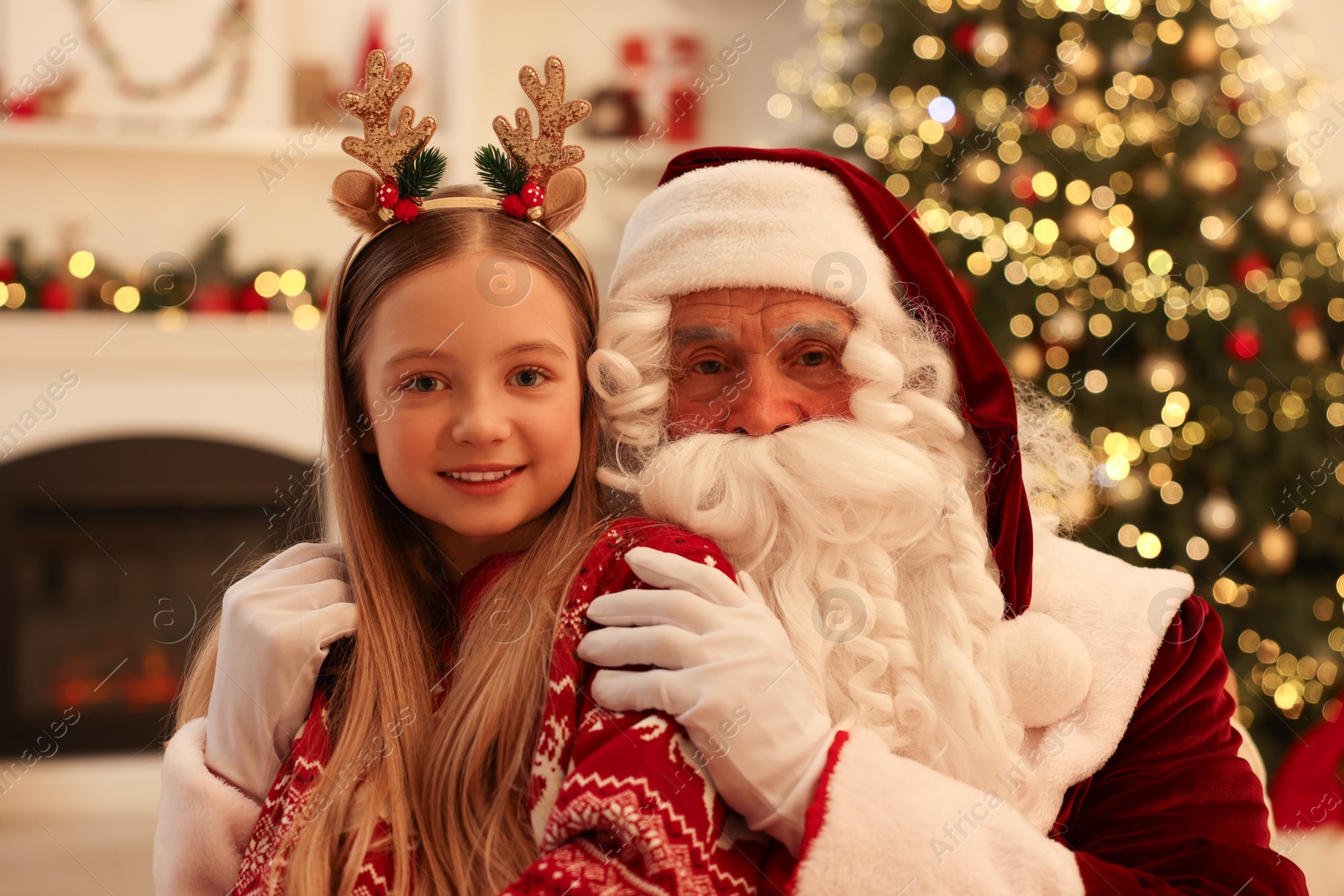 Photo of Christmas celebration. Santa Claus and girl at home