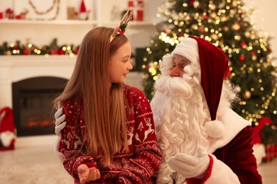 Photo of Christmas celebration. Santa Claus and girl at home