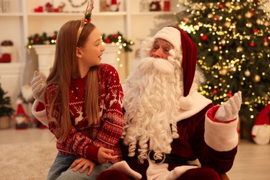 Photo of Christmas celebration. Santa Claus and girl at home