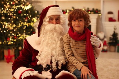 Photo of Christmas celebration. Santa Claus and boy at home