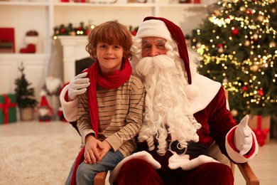 Photo of Christmas celebration. Santa Claus and boy at home