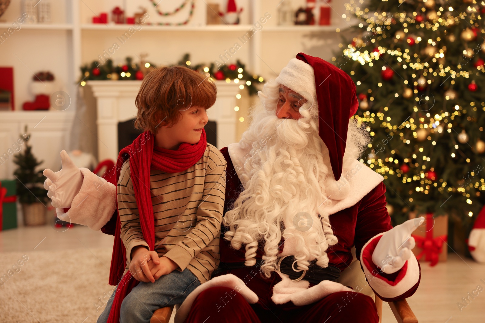 Photo of Christmas celebration. Santa Claus and boy at home