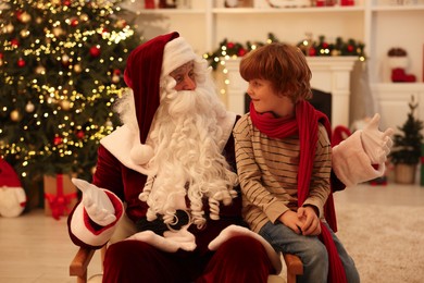 Photo of Christmas celebration. Santa Claus and boy at home