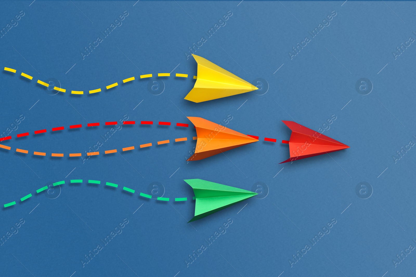 Image of Colorful paper planes with flight paths on blue background. Dashed lines for trajectory