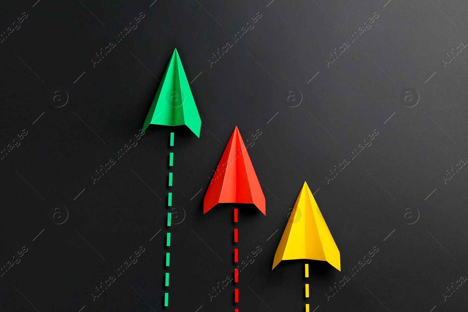 Image of Colorful paper planes with flight paths on black background. Dashed lines for trajectory