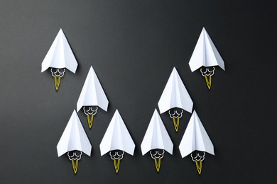 Image of White paper planes rushing forward on black background