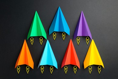 Image of Colorful paper planes rushing forward on black background