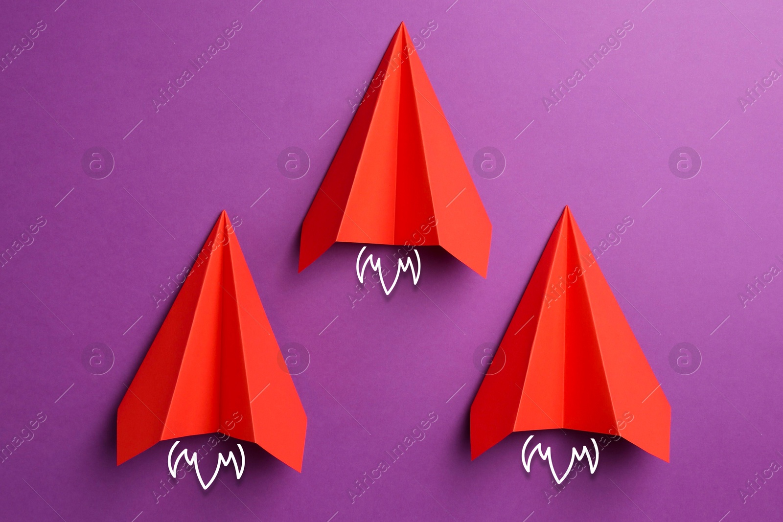 Image of Red paper planes rushing forward on purple background