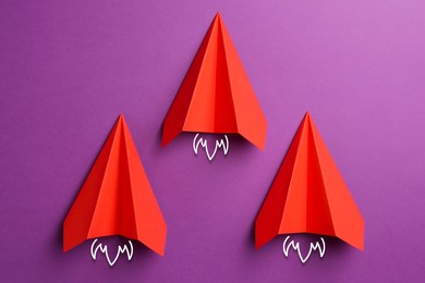 Image of Red paper planes rushing forward on purple background