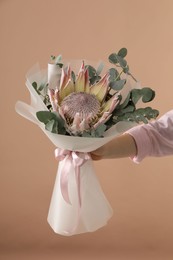 Photo of Woman with beautiful bouquet on brown background, closeup