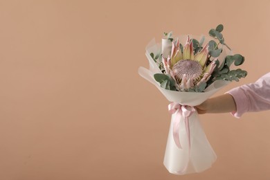 Photo of Woman with beautiful bouquet on brown background, closeup. Space for text