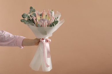 Photo of Woman with beautiful bouquet on brown background, closeup. Space for text