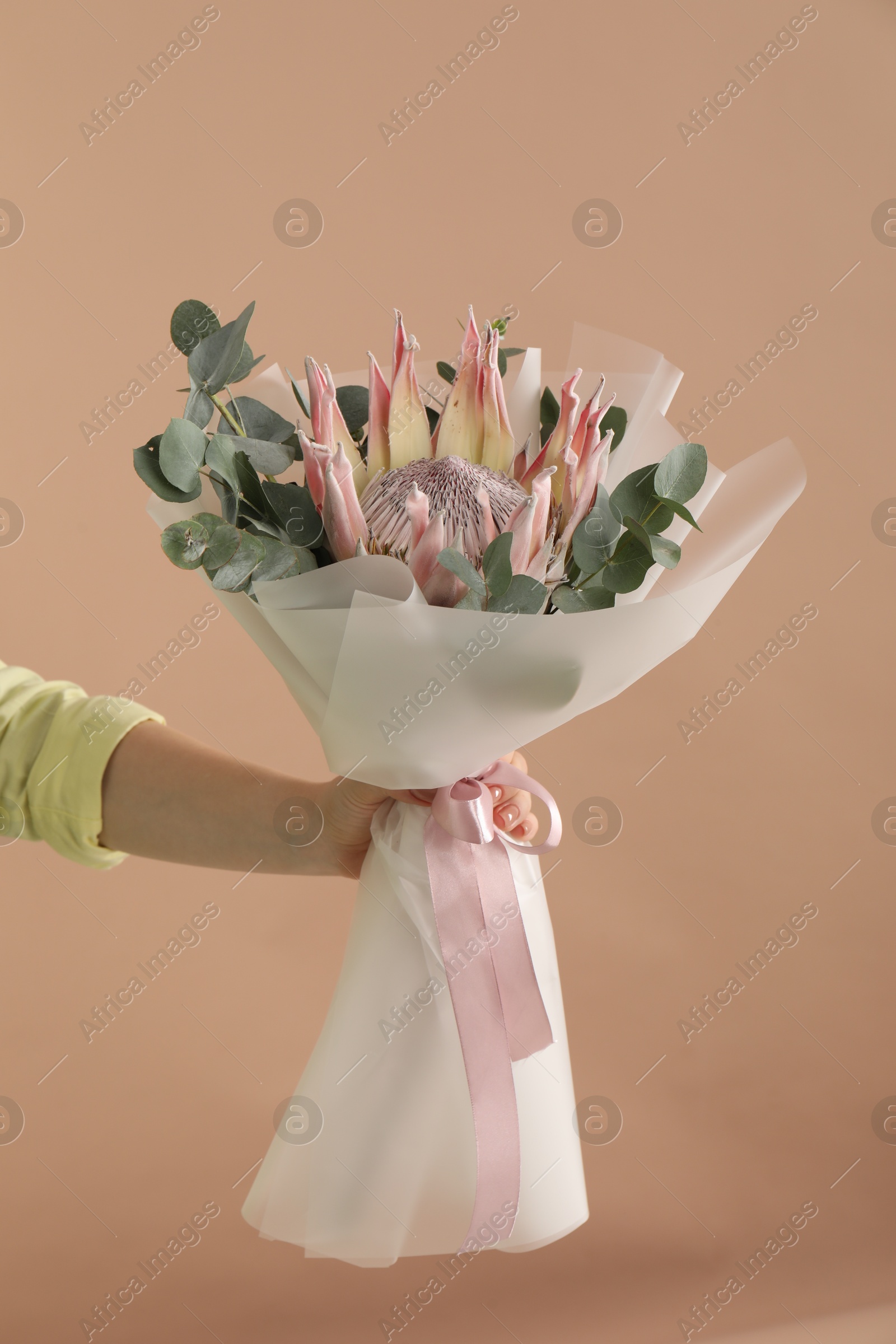 Photo of Woman with beautiful bouquet on brown background, closeup