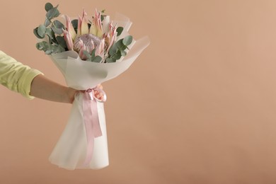 Photo of Woman with beautiful bouquet on brown background, closeup. Space for text