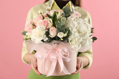 Photo of Florist with beautiful bouquet in box on pink background, closeup