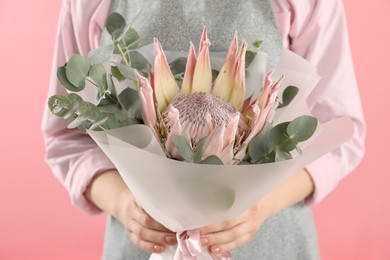 Photo of Florist with beautiful bouquet on pink background, closeup