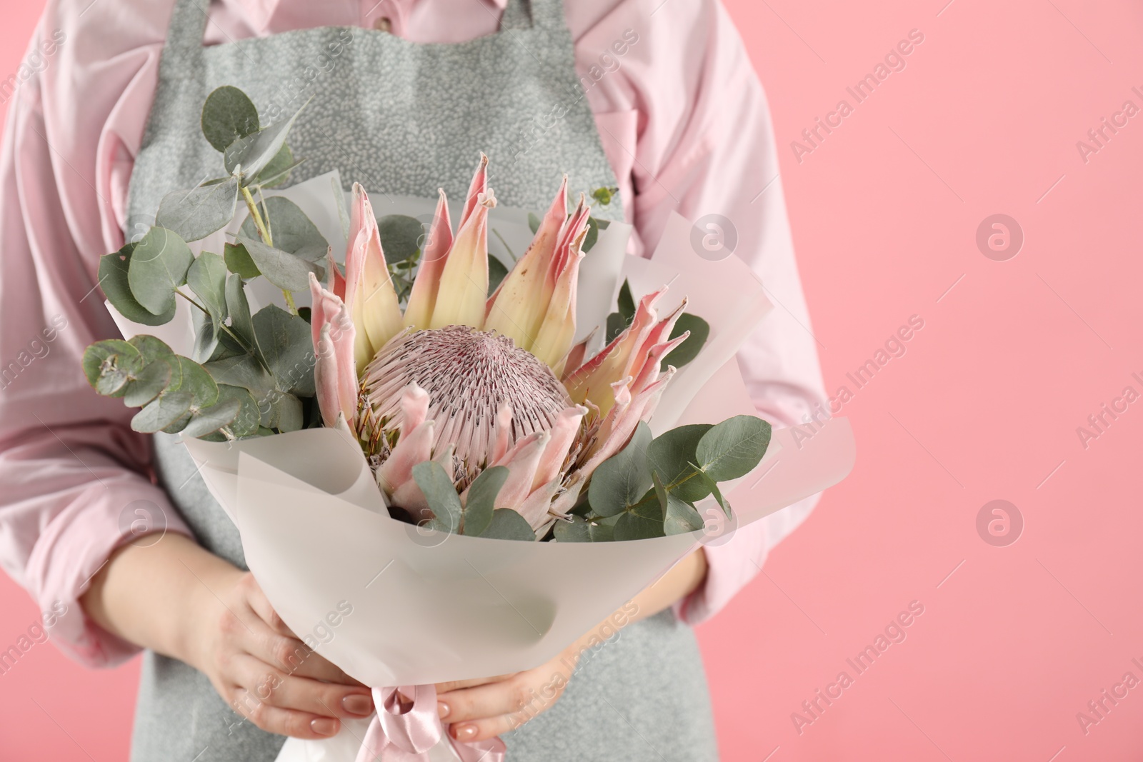 Photo of Florist with beautiful bouquet on pink background, closeup