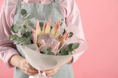 Photo of Florist with beautiful bouquet on pink background, closeup