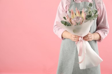 Photo of Florist with beautiful bouquet on pink background, closeup. Space for text