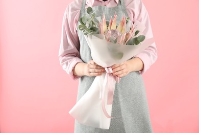 Photo of Florist with beautiful bouquet on pink background, closeup