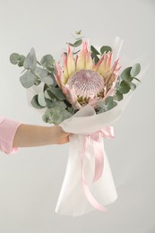 Photo of Woman with beautiful bouquet on light background, closeup